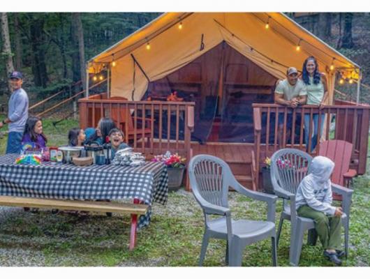 Family enjoying picnic by luxury tent