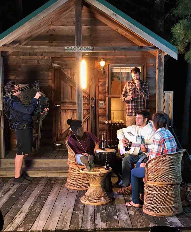 campers enjoying guitar player in front of cabin